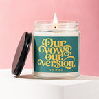 Candle with teal label reading "Our vows, our version, vowed" in yellow script.