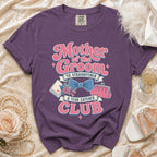 Purple t-shirt with "Mother of the Groom Tie Straightener & Tear Catcher Club" graphic.