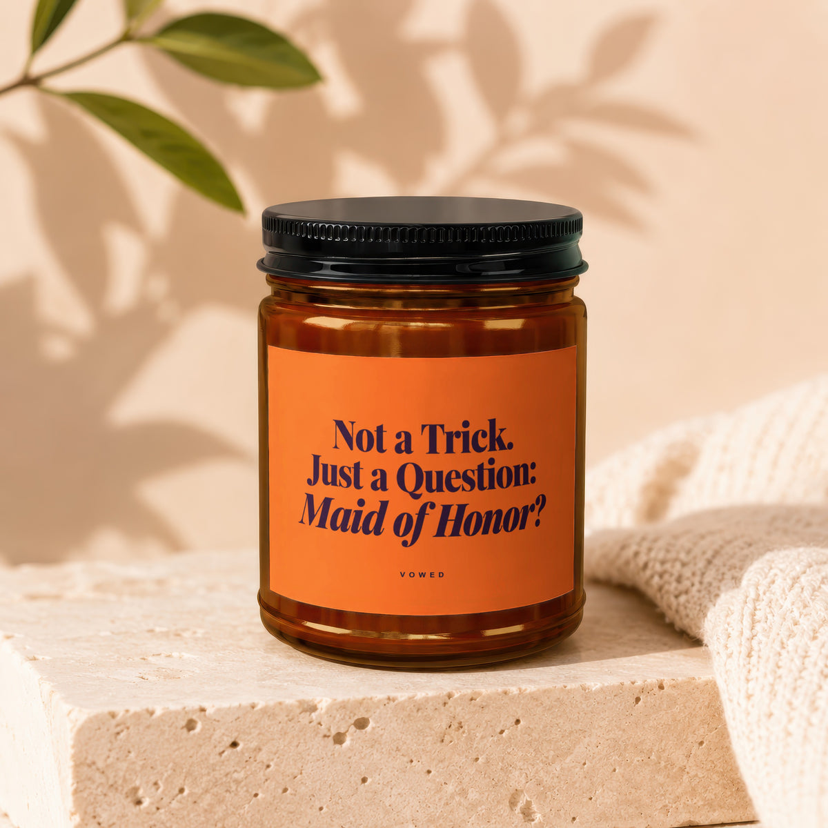 Candle with orange label reading "Not a Trick. Just a Question: Maid of Honor?".