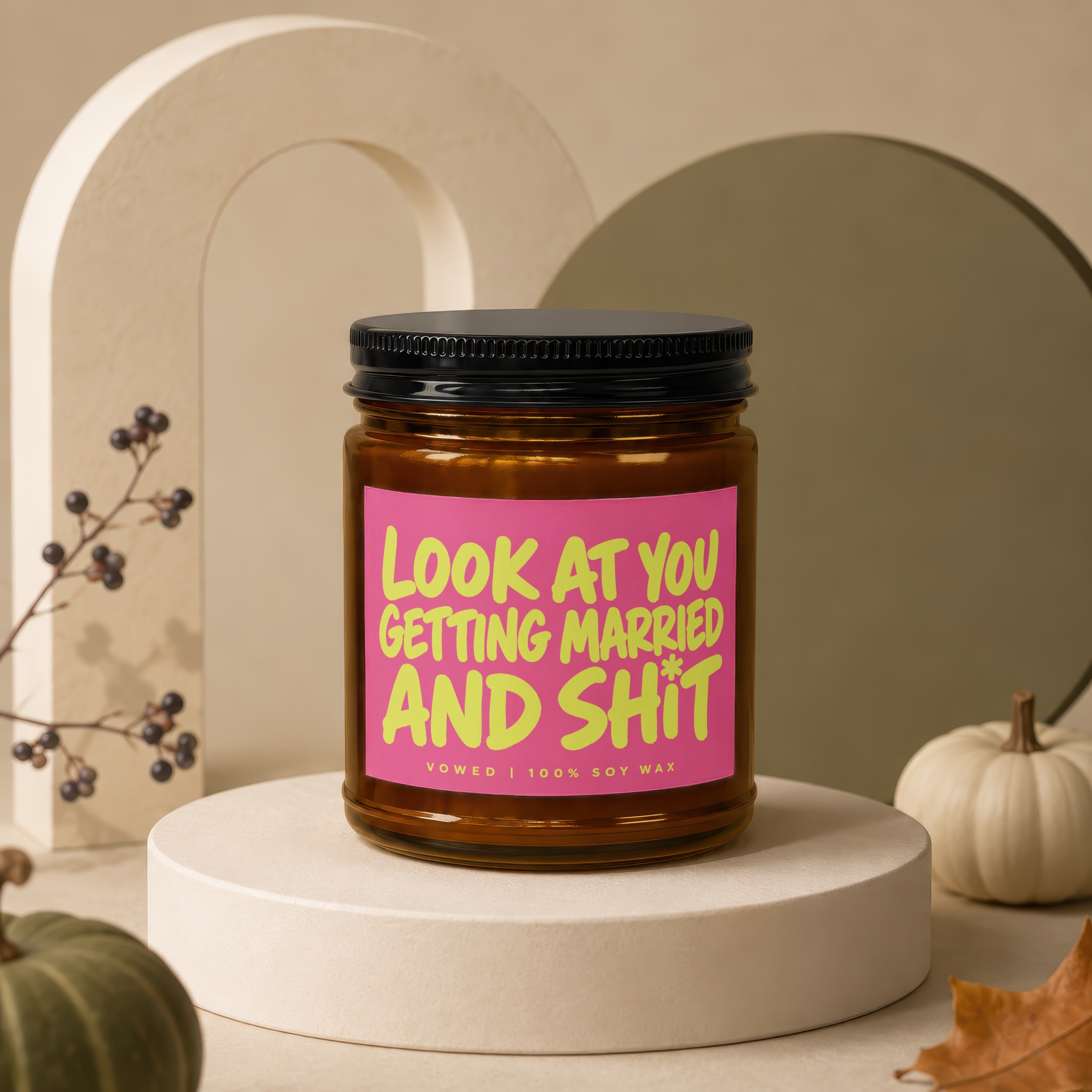 Amber candle with pink label reading "Look at you getting married and shit".
