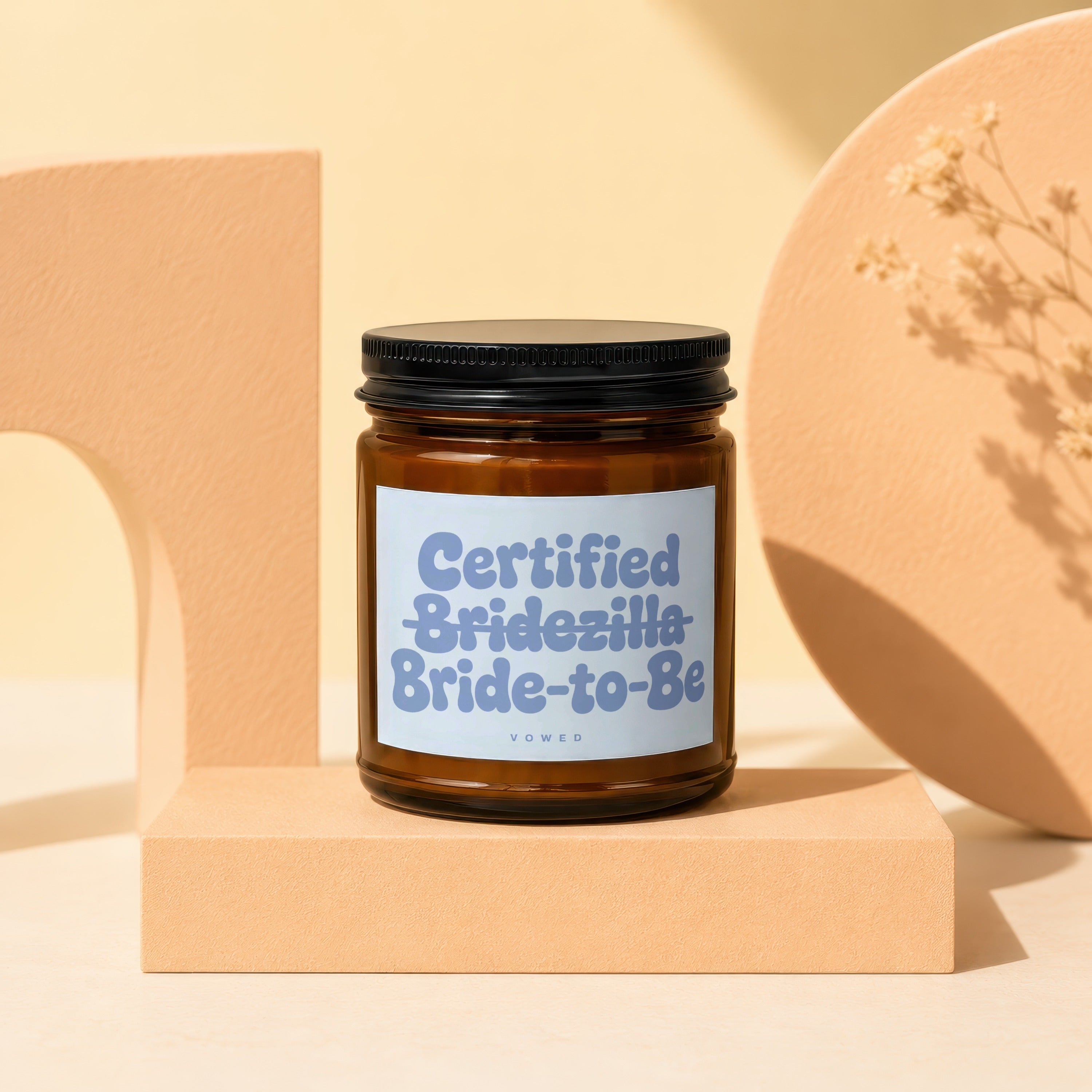 Amber glass candle with "Certified Bridezilla Bride-to-Be" label on pedestal.