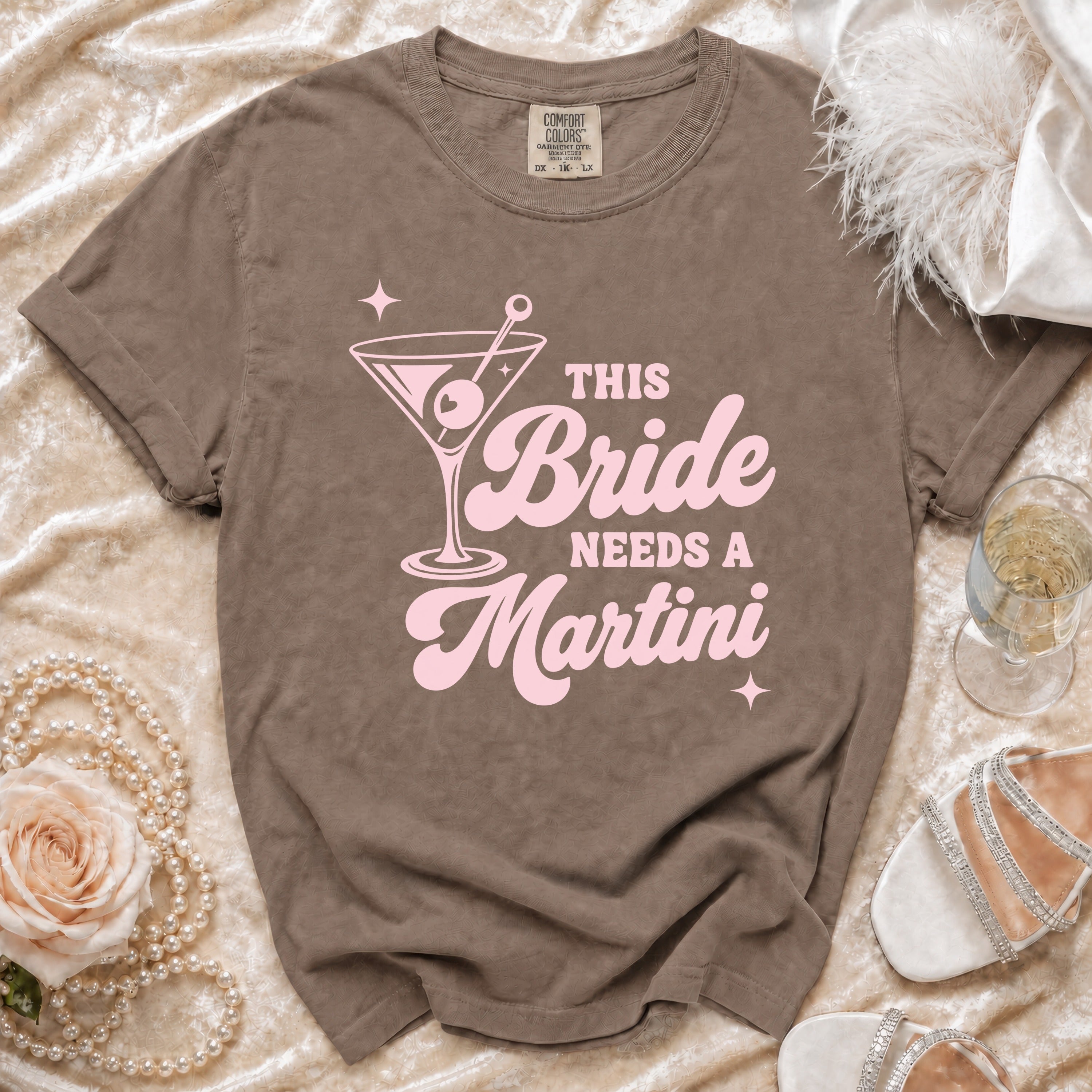 Brown t-shirt with pink "This Bride Needs a Martini" graphic and martini glass.