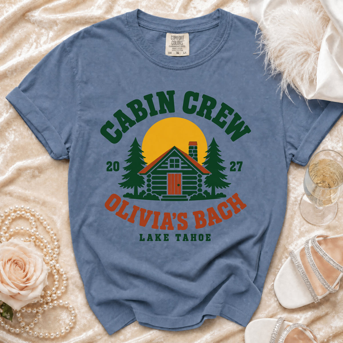 Blue t-shirt with "Cabin Crew Olivia's Bach Lake Tahoe" text and graphics.