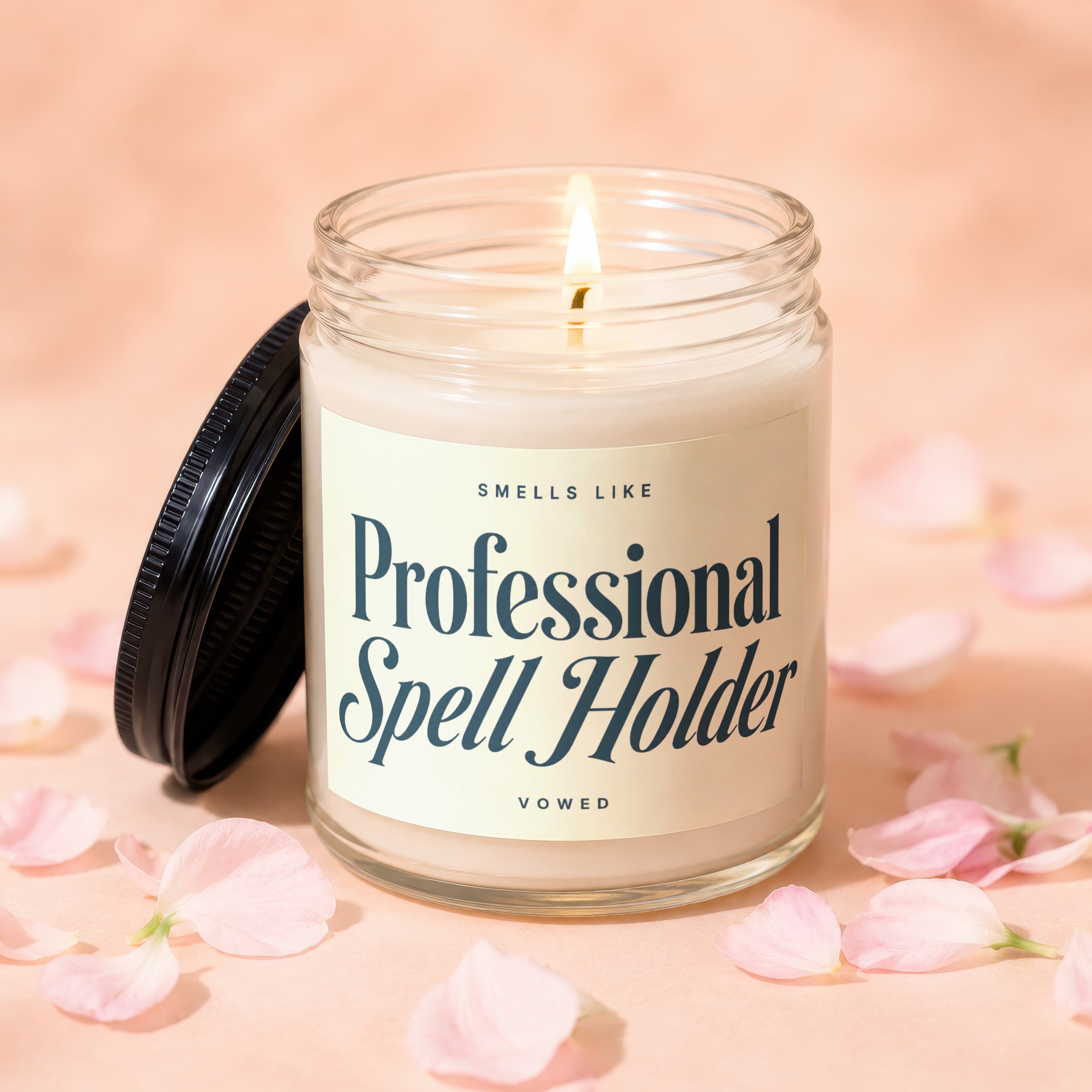Glass candle with "Professional Spell Holder" text surrounded by pink petals.