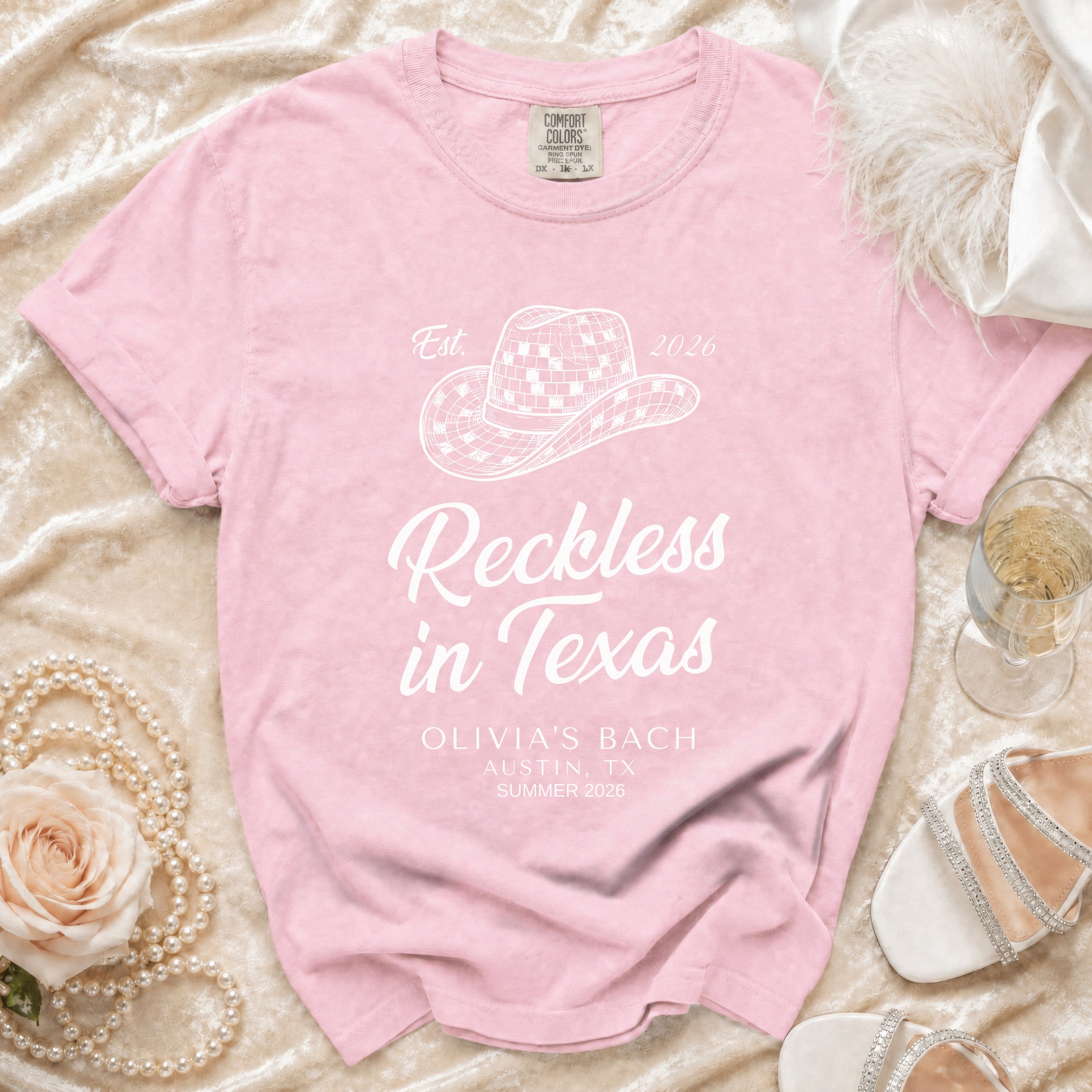 Pink t-shirt with "Reckless in Texas" and event details.