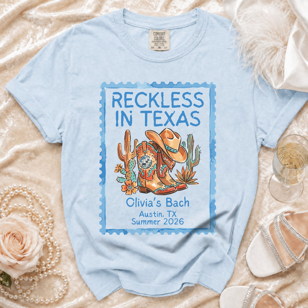 Light blue t-shirt with "Reckless in Texas" and "Olivia's Bach" design.