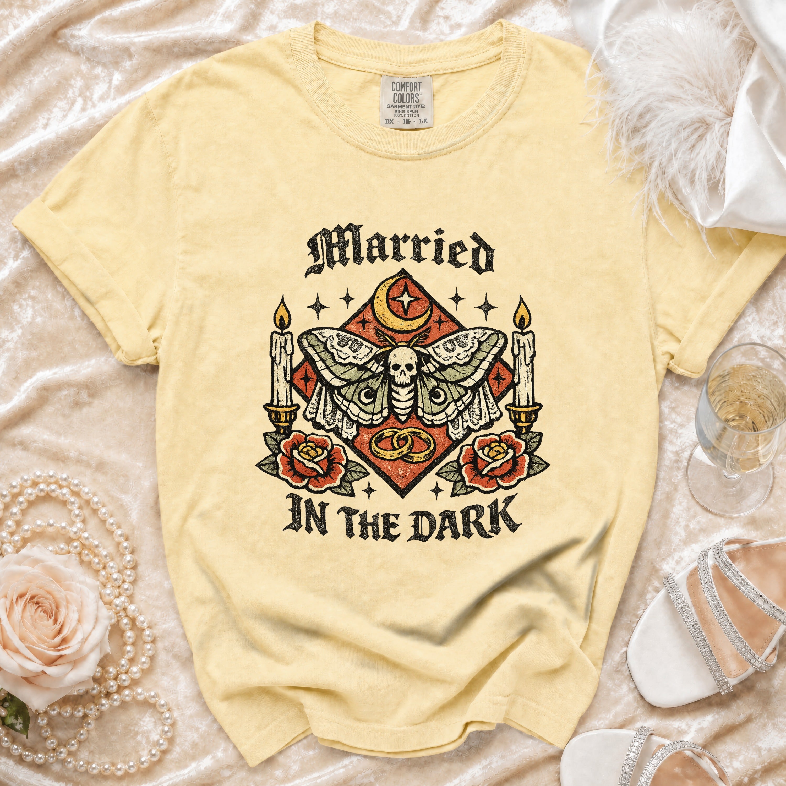 Yellow t-shirt with "Married In The Dark" graphic featuring a moth, skull, candles, and rings.