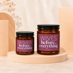 Two amber glass candles labeled "Wives before... everything" on display stands.