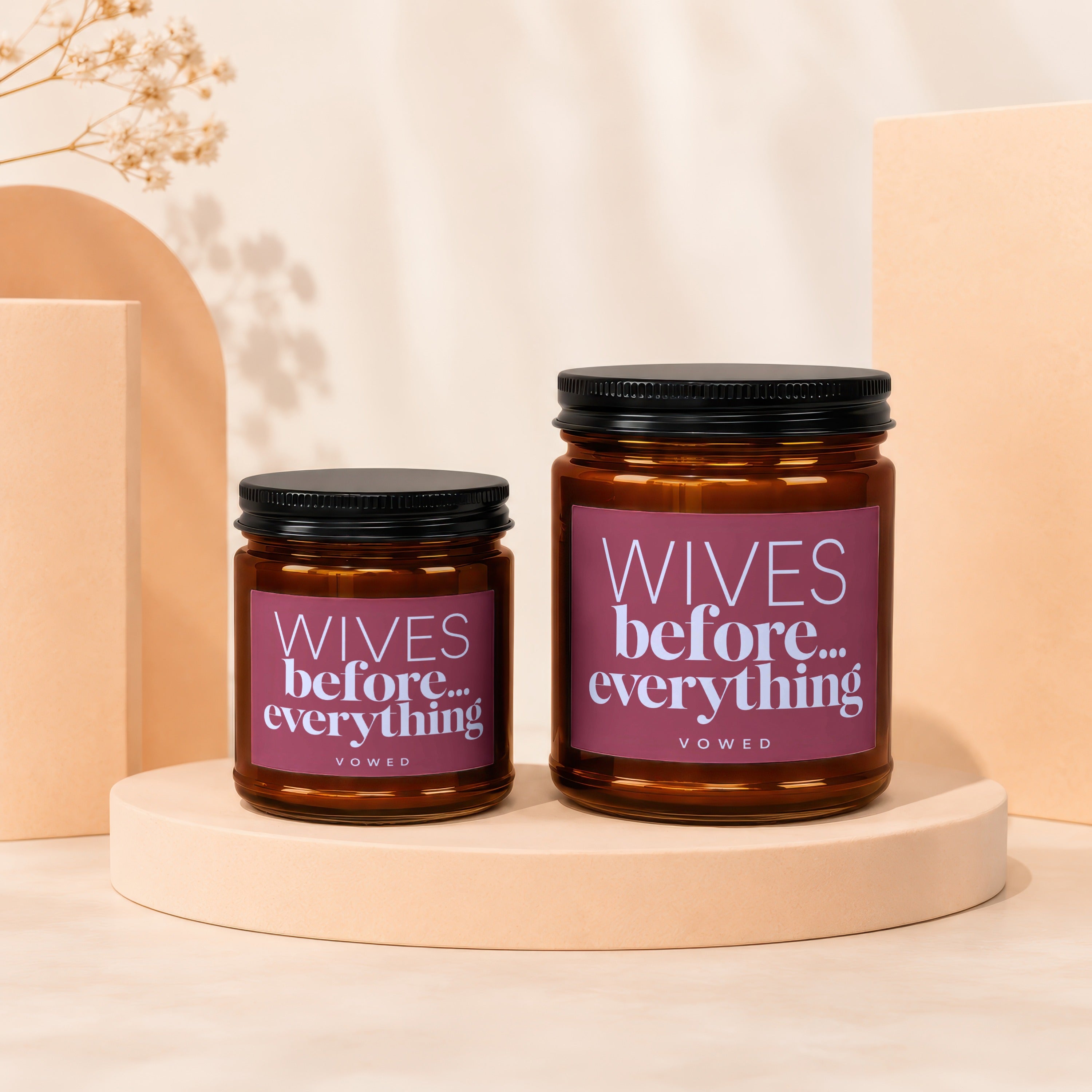 Two amber glass candles labeled "Wives before... everything" on display stands.