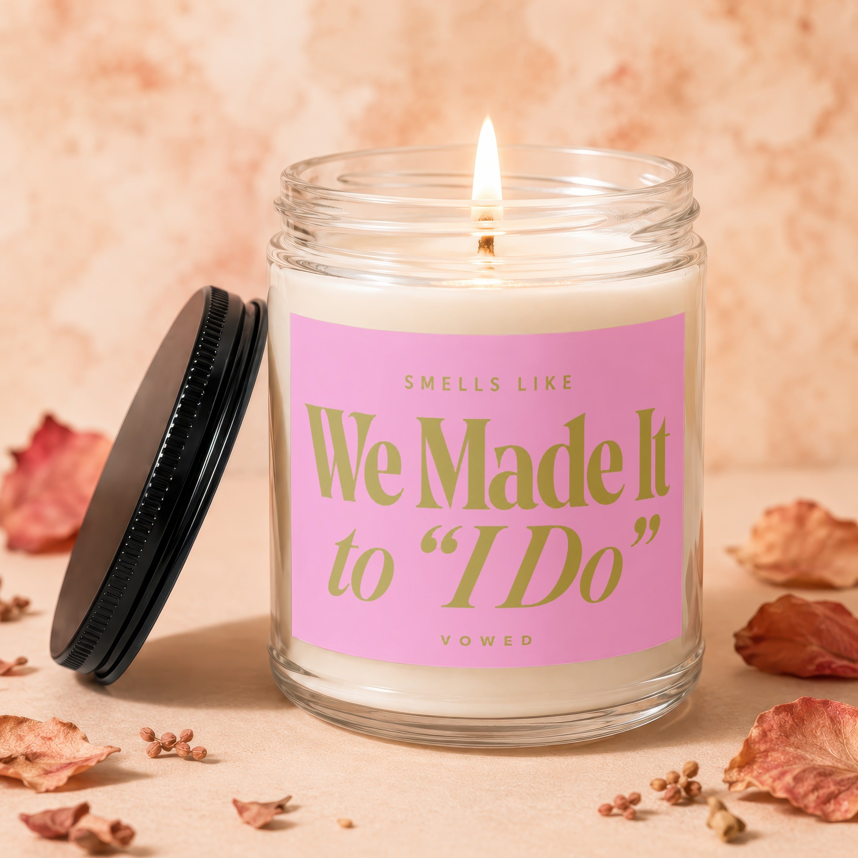 Glass candle with pink label that reads "Smells like We Made It to 'I Do'".