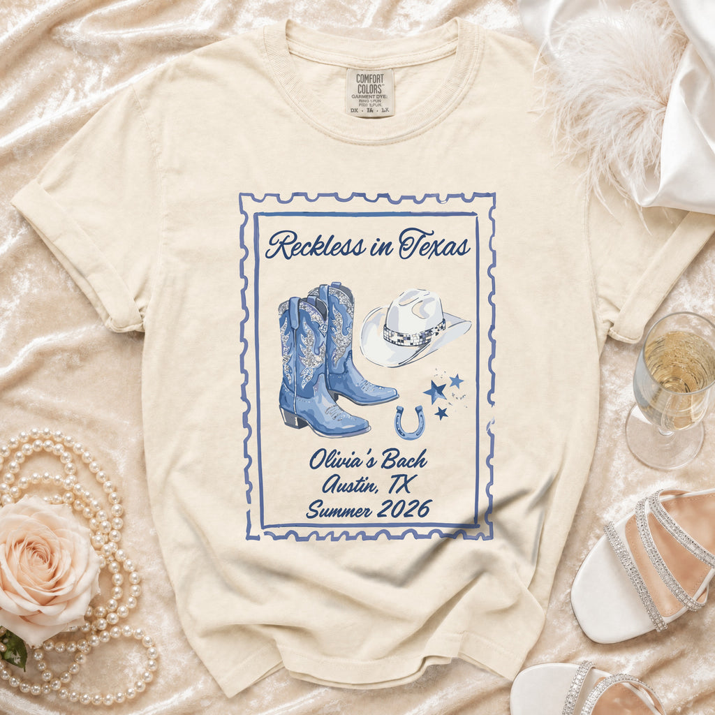 Cream t-shirt with "Reckless in Texas" stamp design, cowboy boots, hat, and horseshoe.