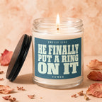 Candle with lit wick and "HE FINALLY PUT A RING ON IT" text.