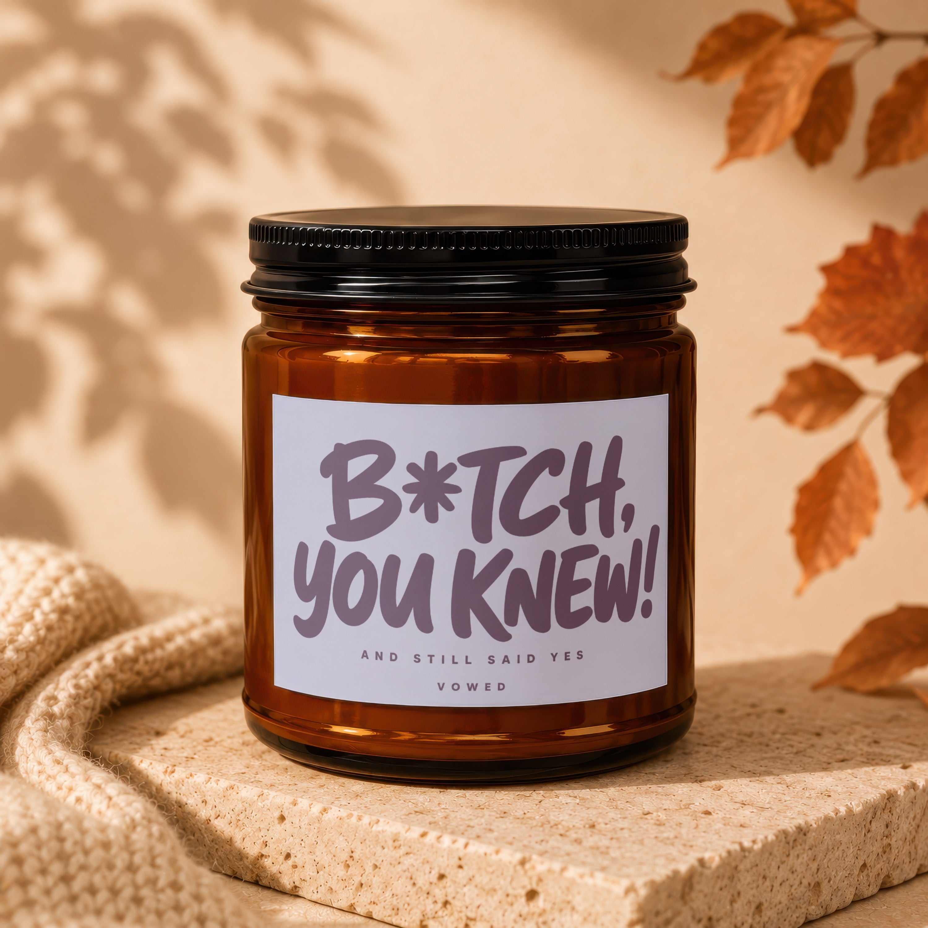 Amber jar candle with label reading "B*tch, you knew! And still said yes. Vowed"