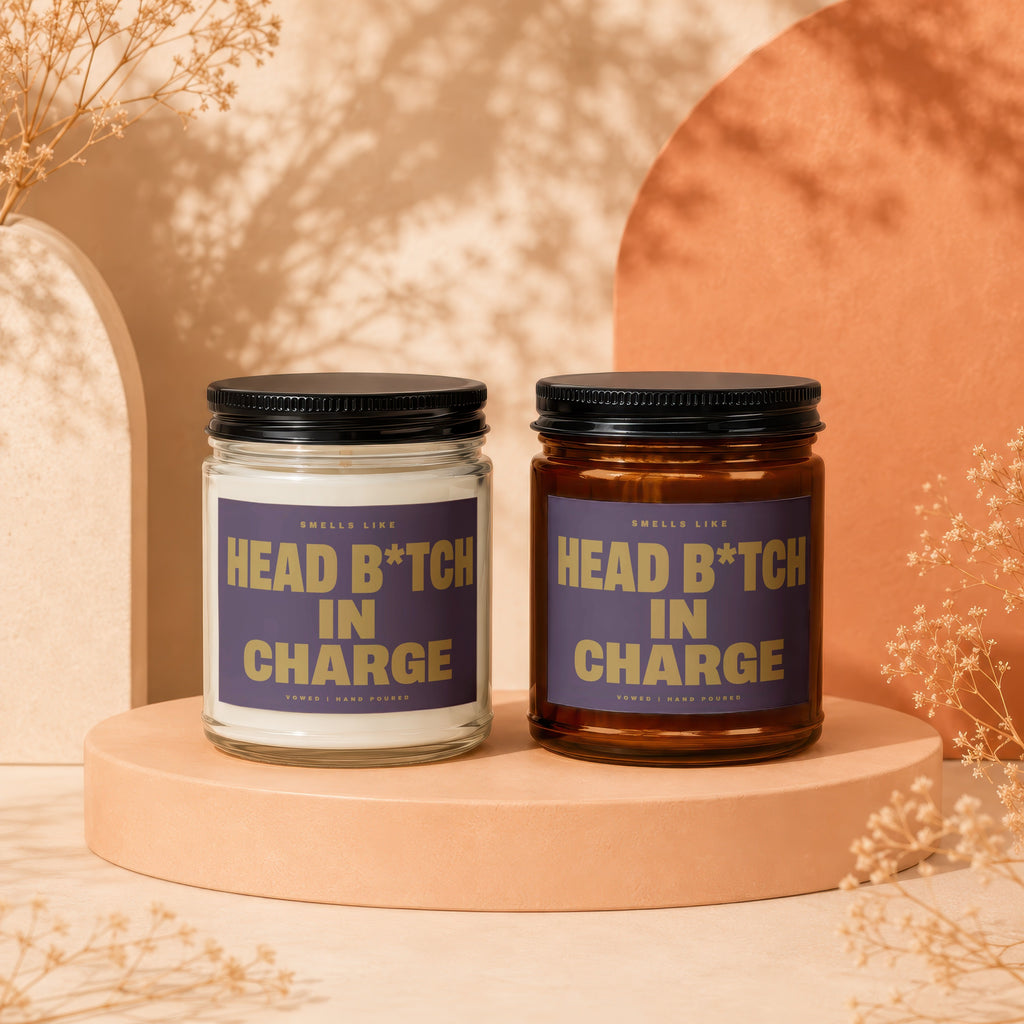 Two candles with "Head B*tch In Charge" text on purple labels.