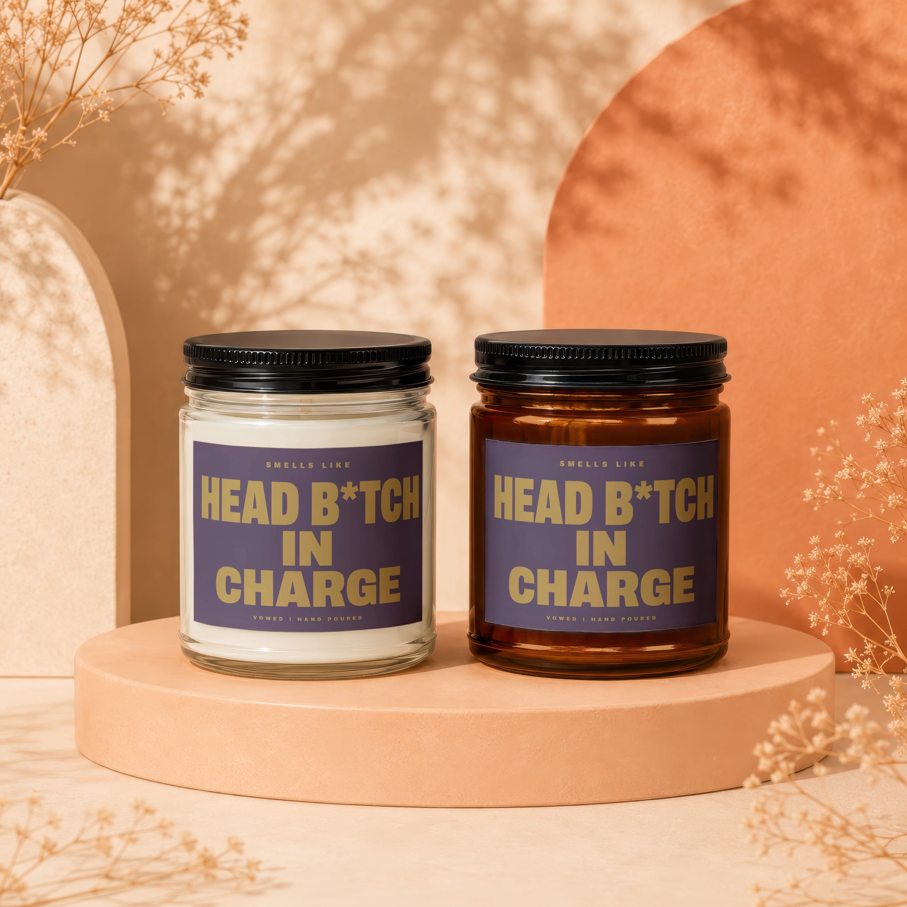 Two candles with "Head B*tch In Charge" text on purple labels.