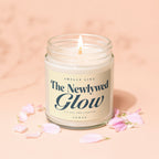 Lit candle with "The Newlywed Glow" label surrounded by pink petals.