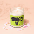 Engaged AF. candle in a glass jar with a lit wick and pink petals.