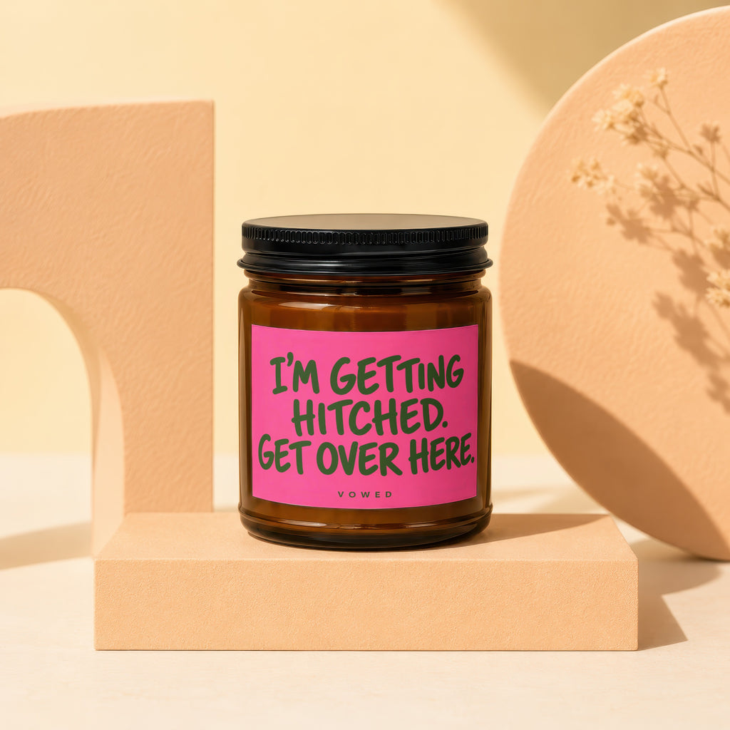 Brown glass candle with pink label reading "I'm Getting Hitched. Get Over Here."