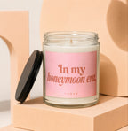 Glass candle with pink label reading "In my honeymoon era. VOWED."