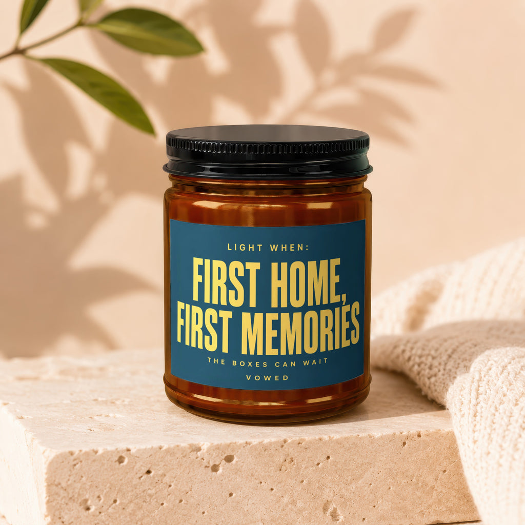 Glass candle with text "First Home, First Memories" on a blue label.