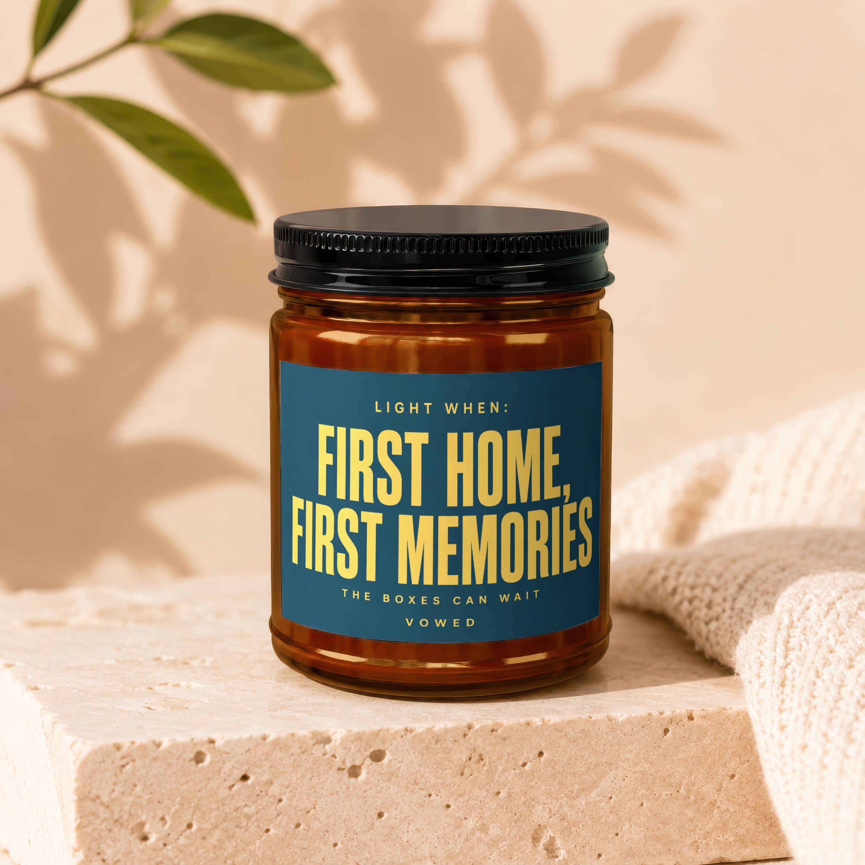 Glass candle with text "First Home, First Memories" on a blue label.