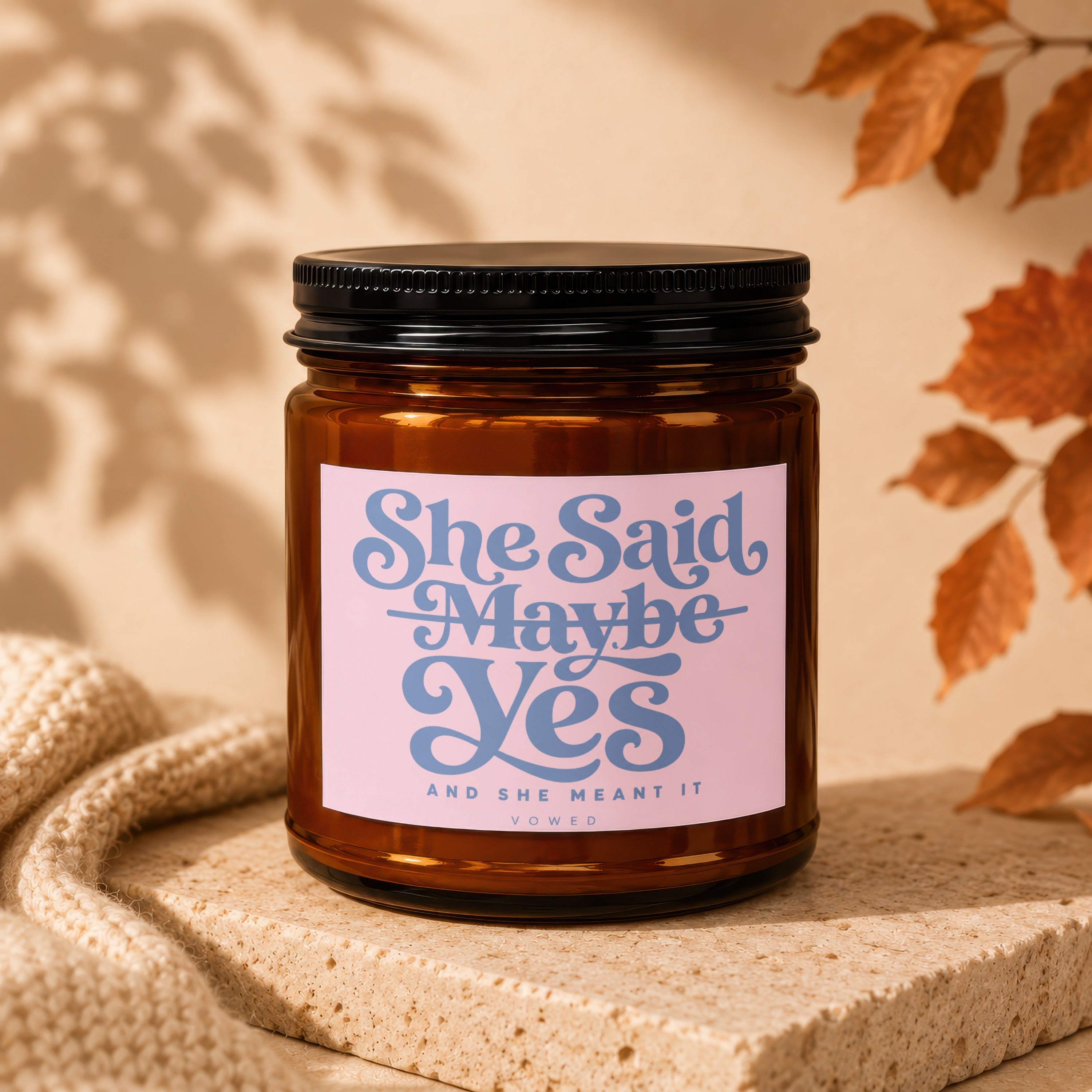Amber candle with pink label reading "She Said Maybe Yes And She Meant It".