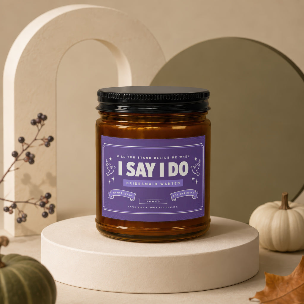 Amber jar candle with purple label asking, "Will you stand beside me when I say I do?"