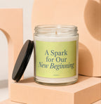 Glass jar candle with "A Spark for Our New Beginning" text.