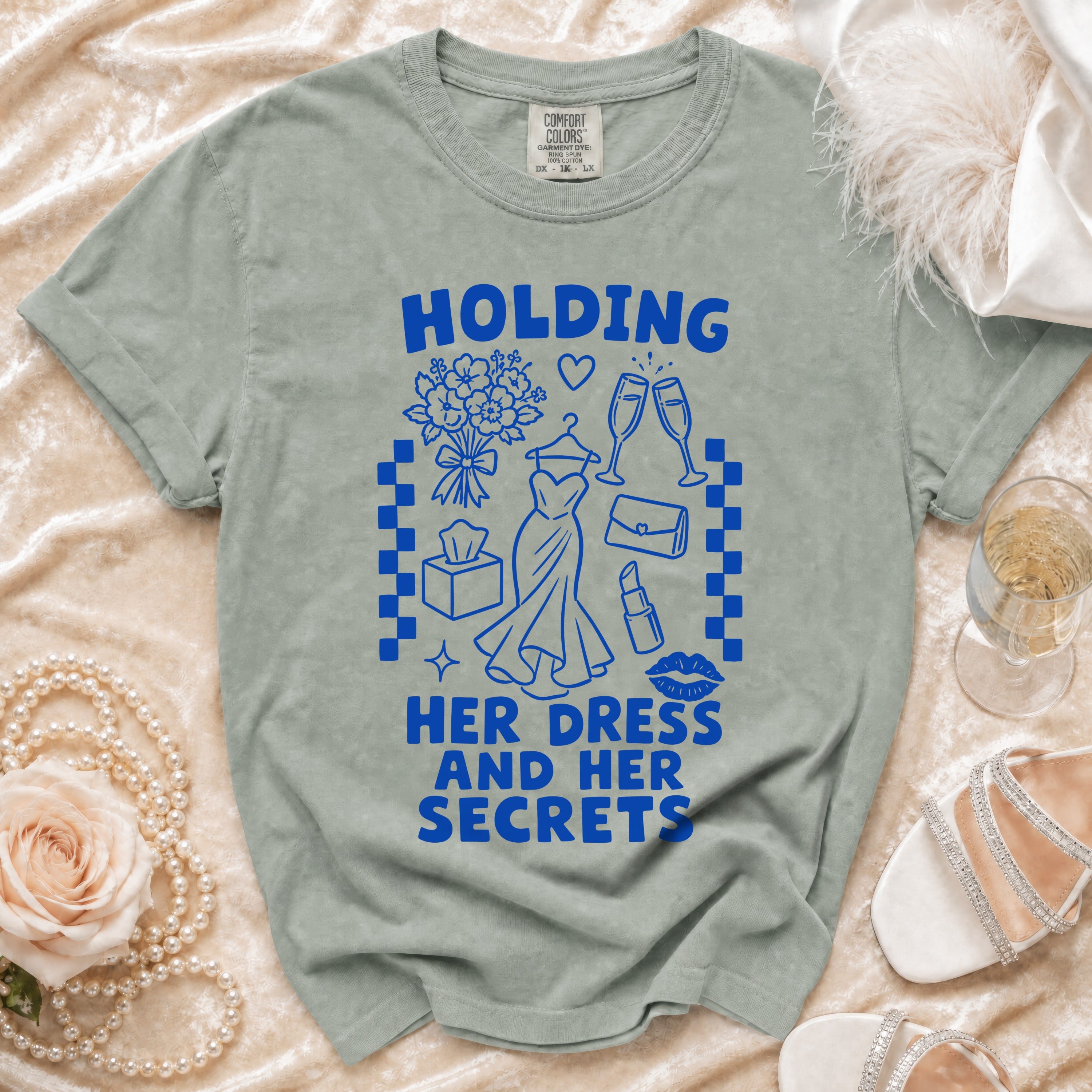 Green t-shirt with blue graphic of "Holding Her Dress And Her Secrets".