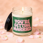 Jar candle with pink text reading "Smells Like You're Getting Married" surrounded by petals.