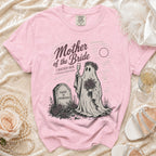 Pink t-shirt with "Mother of the Bride" ghost graphic holding champagne and flowers.