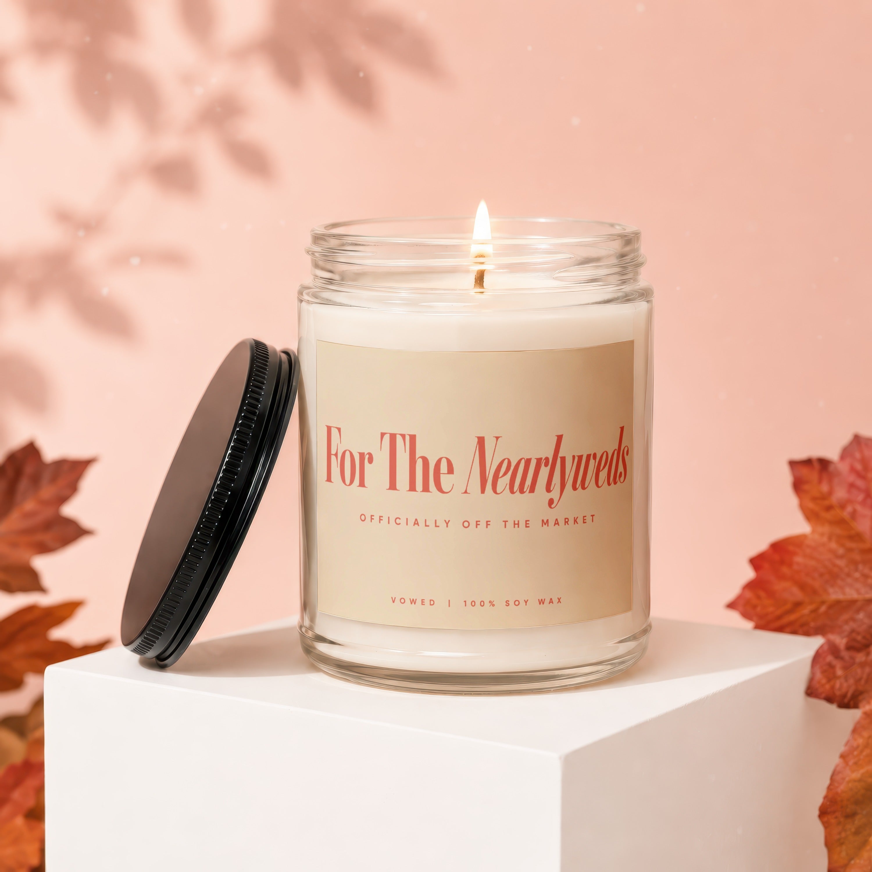 Candle labeled "For The Nearlyweds Officially Off The Market" with a lit wick.
