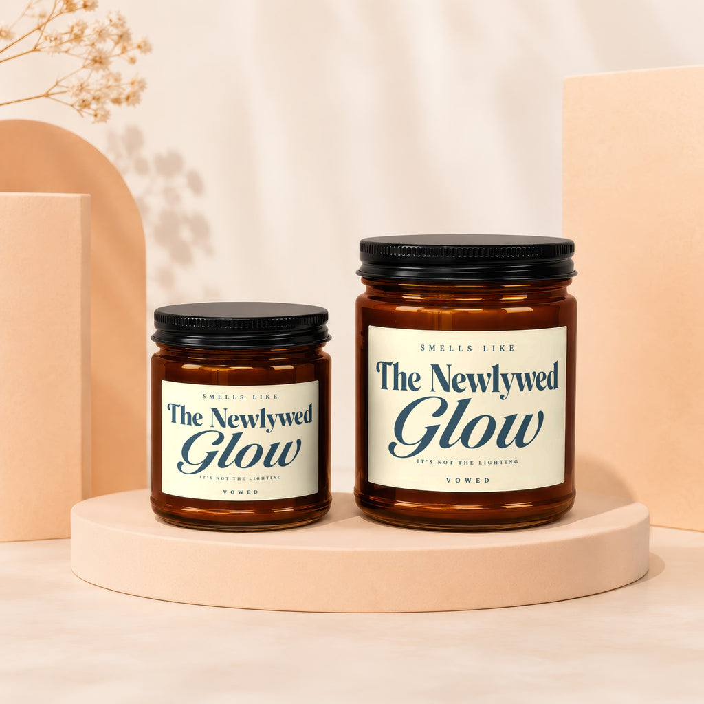 Two amber glass jar candles labeled "The Newlywed Glow" on display pedestals.