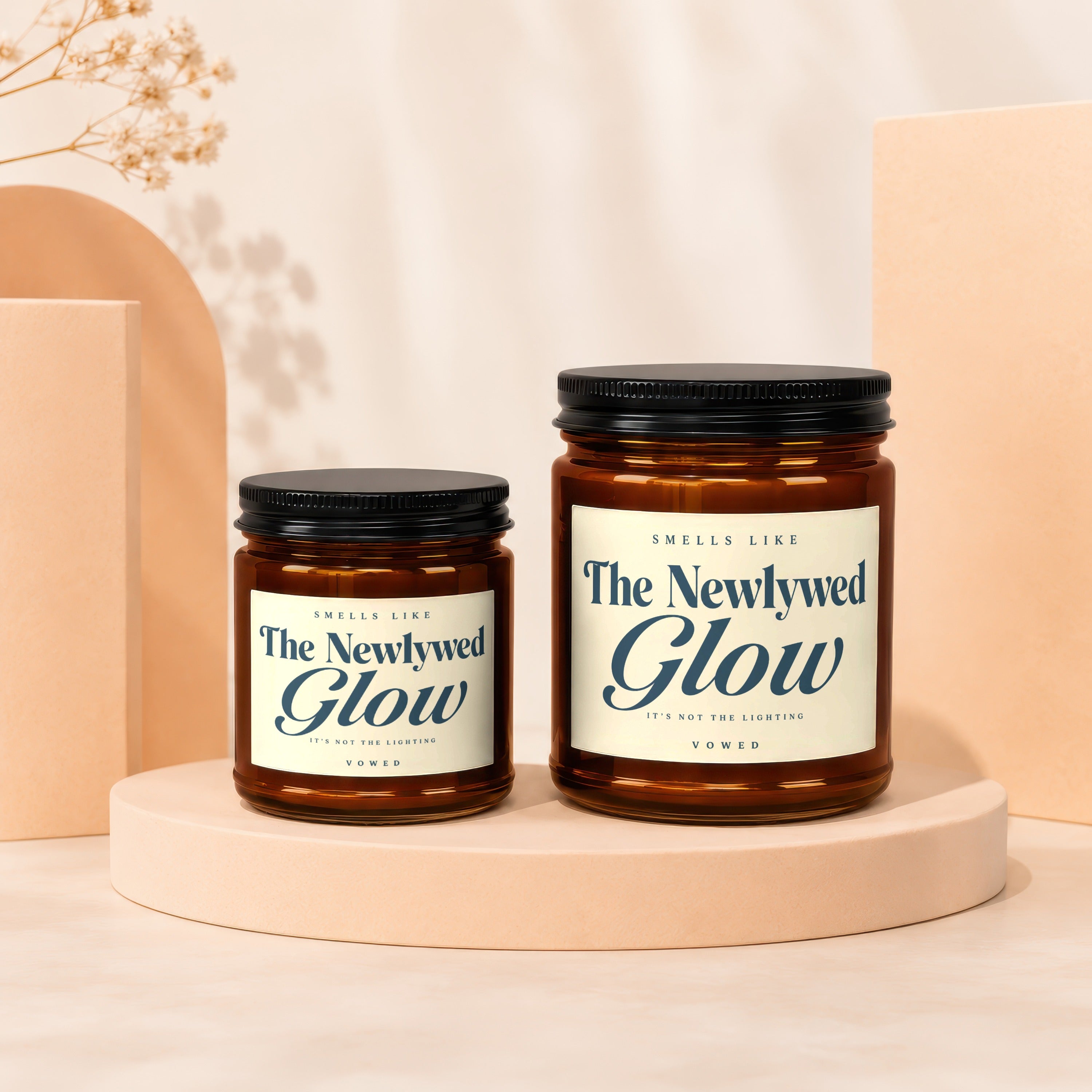 Two amber glass jar candles labeled "The Newlywed Glow" on display pedestals.