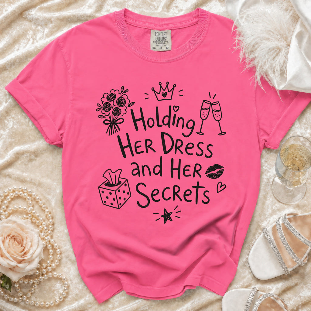 Pink t-shirt with "Holding Her Dress and Her Secrets" text and illustrations.