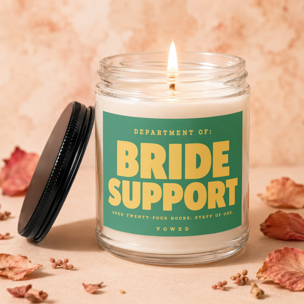 Candle with text "Department of: Bride Support. Open twenty-four hours. Staff of one. Vowed."