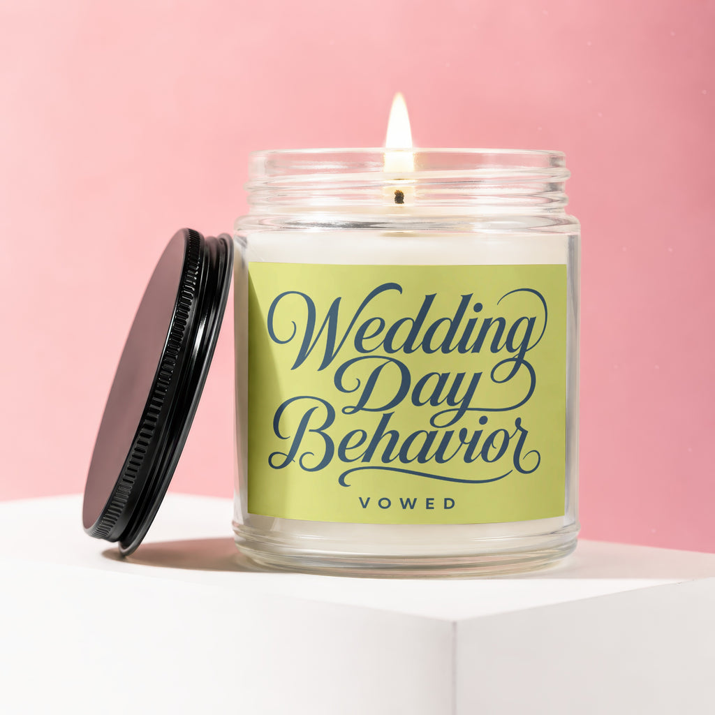 Glass jar candle with lit wick and "Wedding Day Behavior VOWED" text on label.