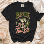 Black t-shirt with "Bride in a Martini Bit" text and cocktail graphic.