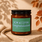 Amber candle with "NOW ACCEPTING Congratulations" on a green label.