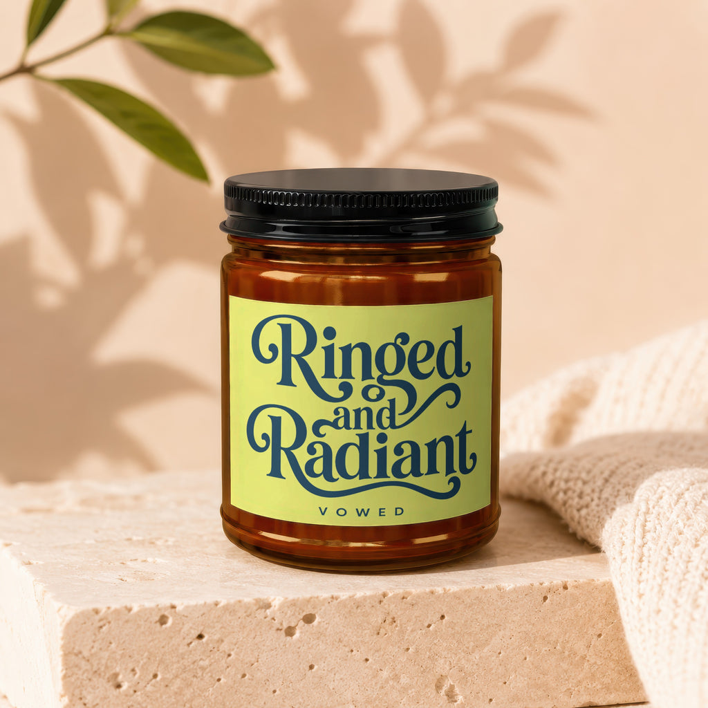 Ringed and Radiant Vowed candle in amber glass jar with black lid.