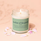 Candle with "mother of the groom" definition and surrounding pink flower petals.