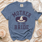 Blue t-shirt with "Mother of the Bride" and witch hat graphic.