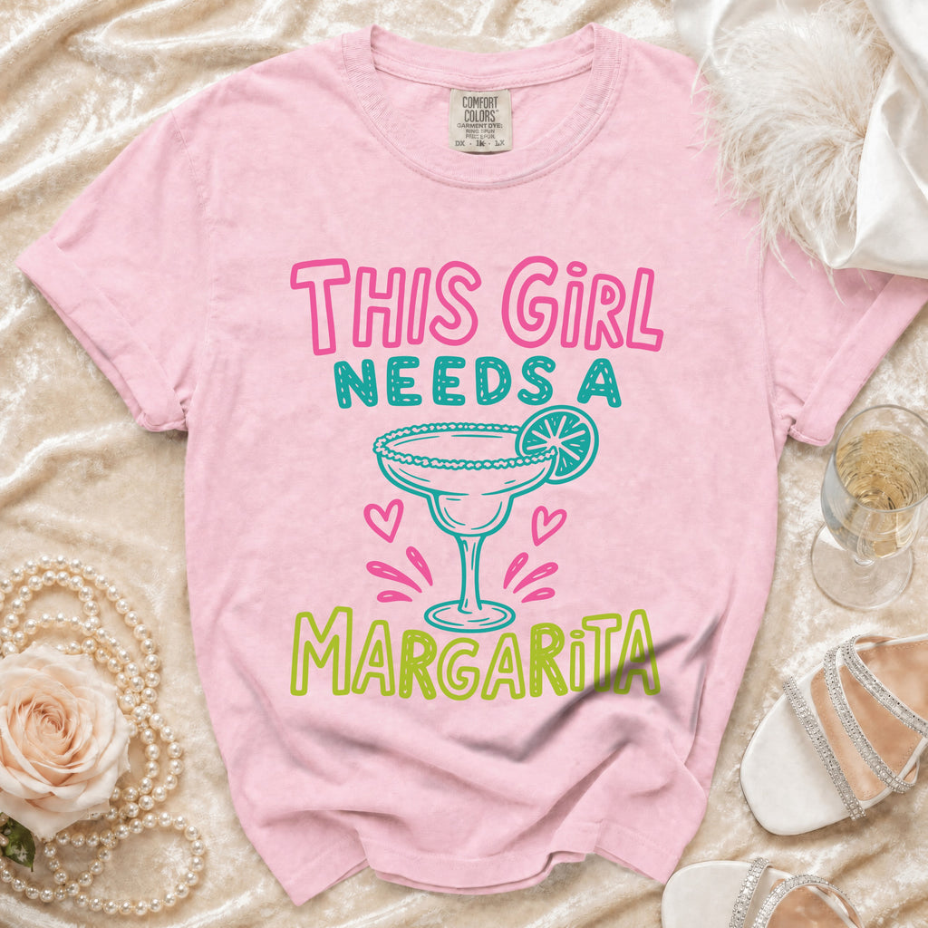 Pink t-shirt with "This Girl Needs A Margarita" graphic and martini glass.