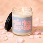Lit candle in glass jar with "Two rings, zero chill" text and "Vowed" below.