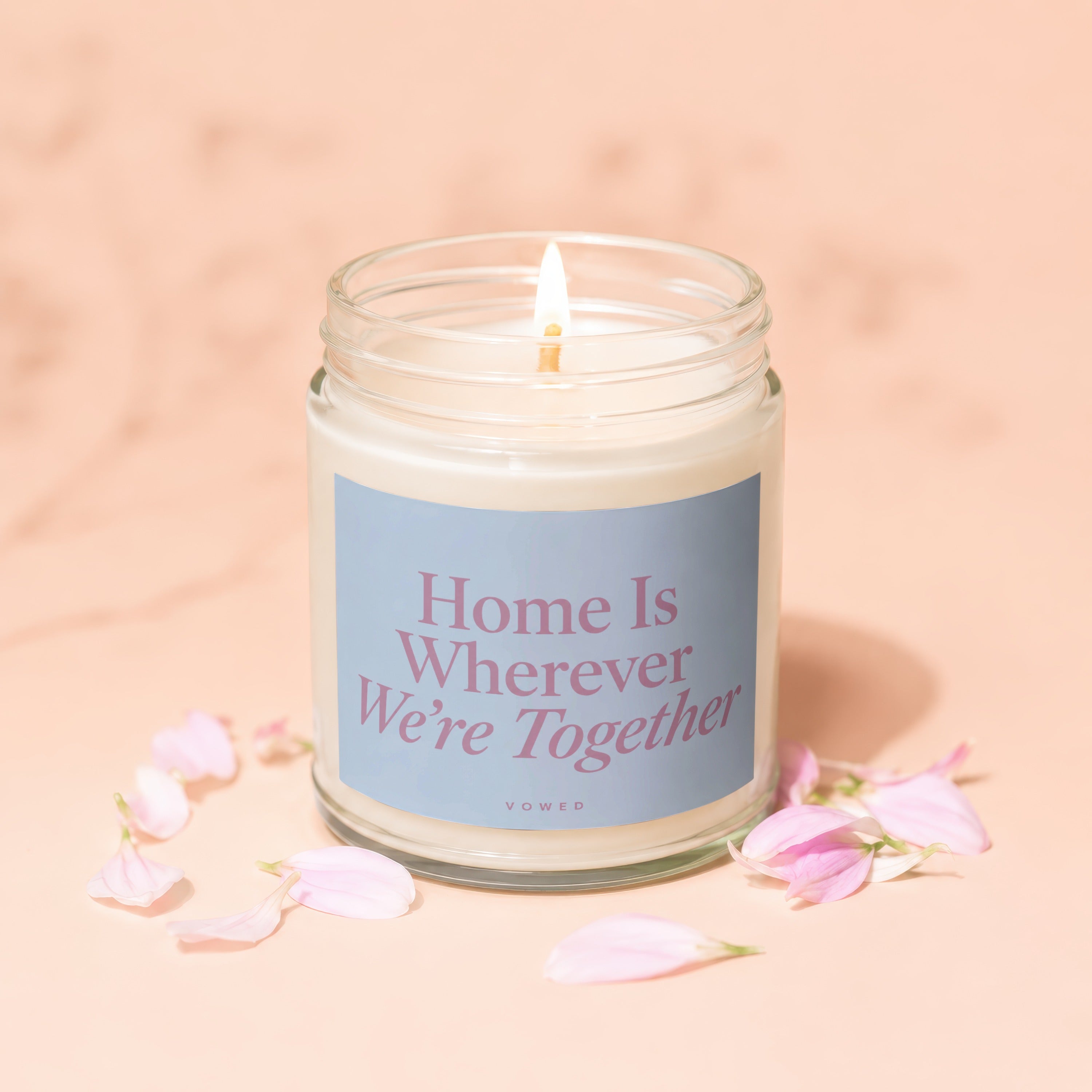 Candle with lit wick and label reading "Home Is Wherever We're Together"