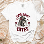 White t-shirt with "This Bride Bites" text and gothic skeleton bride graphic.
