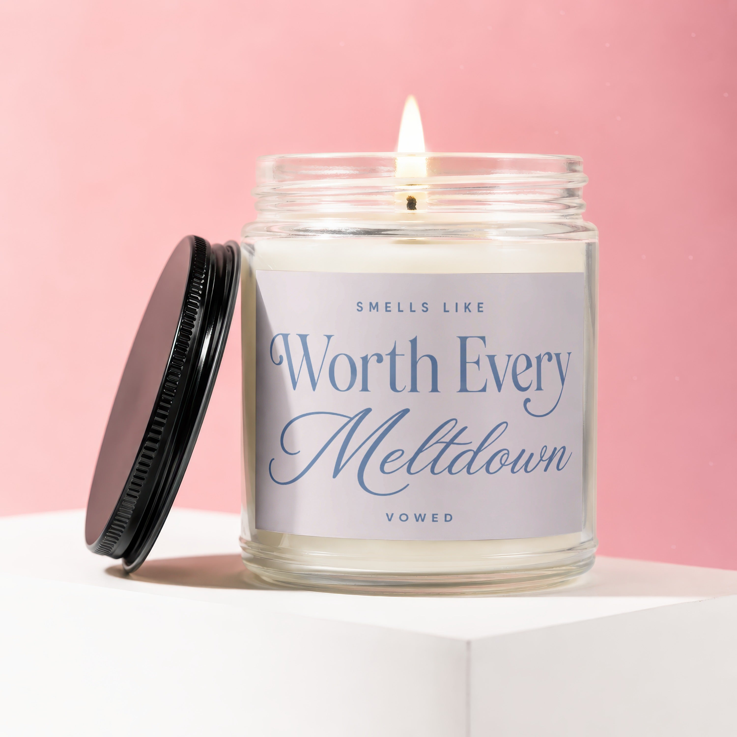 Jar candle with visible flame. Label reads "SMELLS LIKE Worth Every Meltdown VOWED".