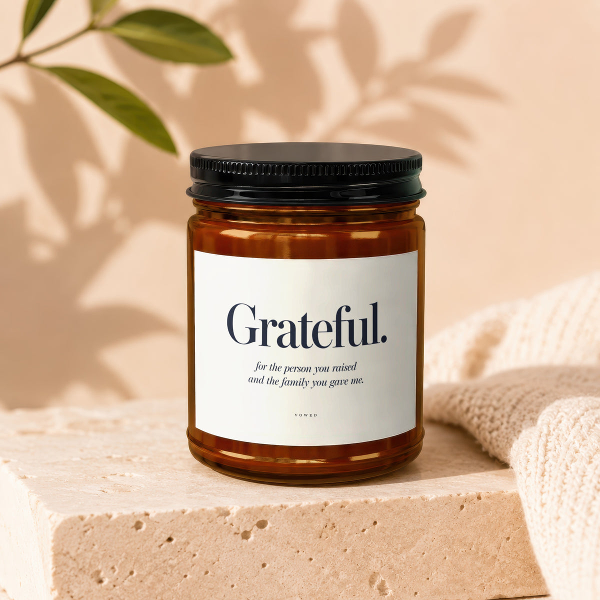 Amber glass candle labeled "Grateful. for the person you raised and the family you gave me."