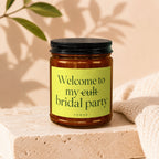 Candle with a black lid and yellow label reading "Welcome to my cult bridal party VOWED".