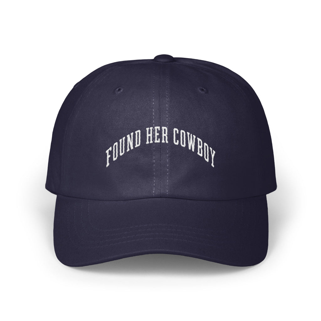 A navy blue baseball cap embroidered with the white arched text FOUND HER COWBOY.